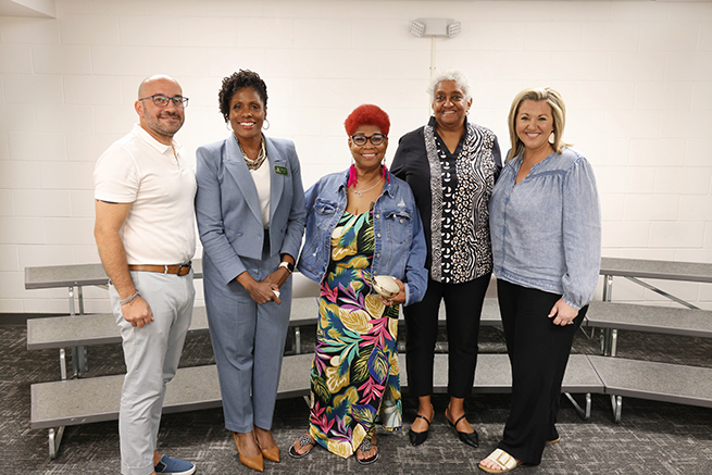 Staff members stand with awards for years of service