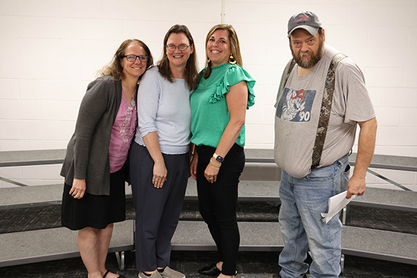 Staff members stand with awards for years of service