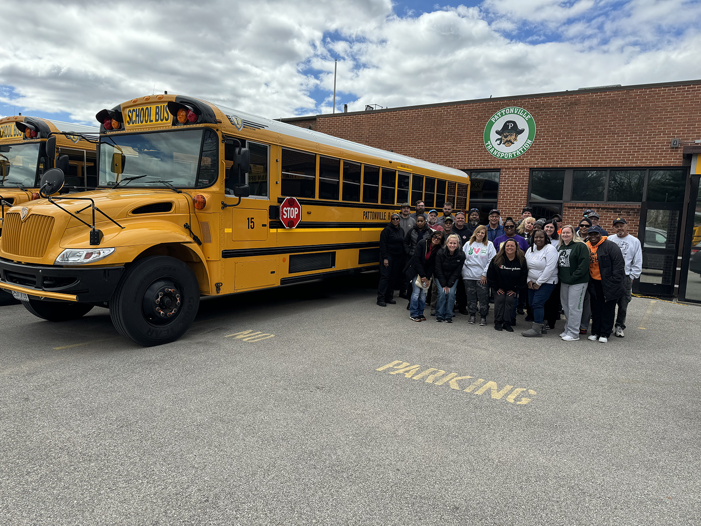 Staff members who participated in the inspect stand next to school bus