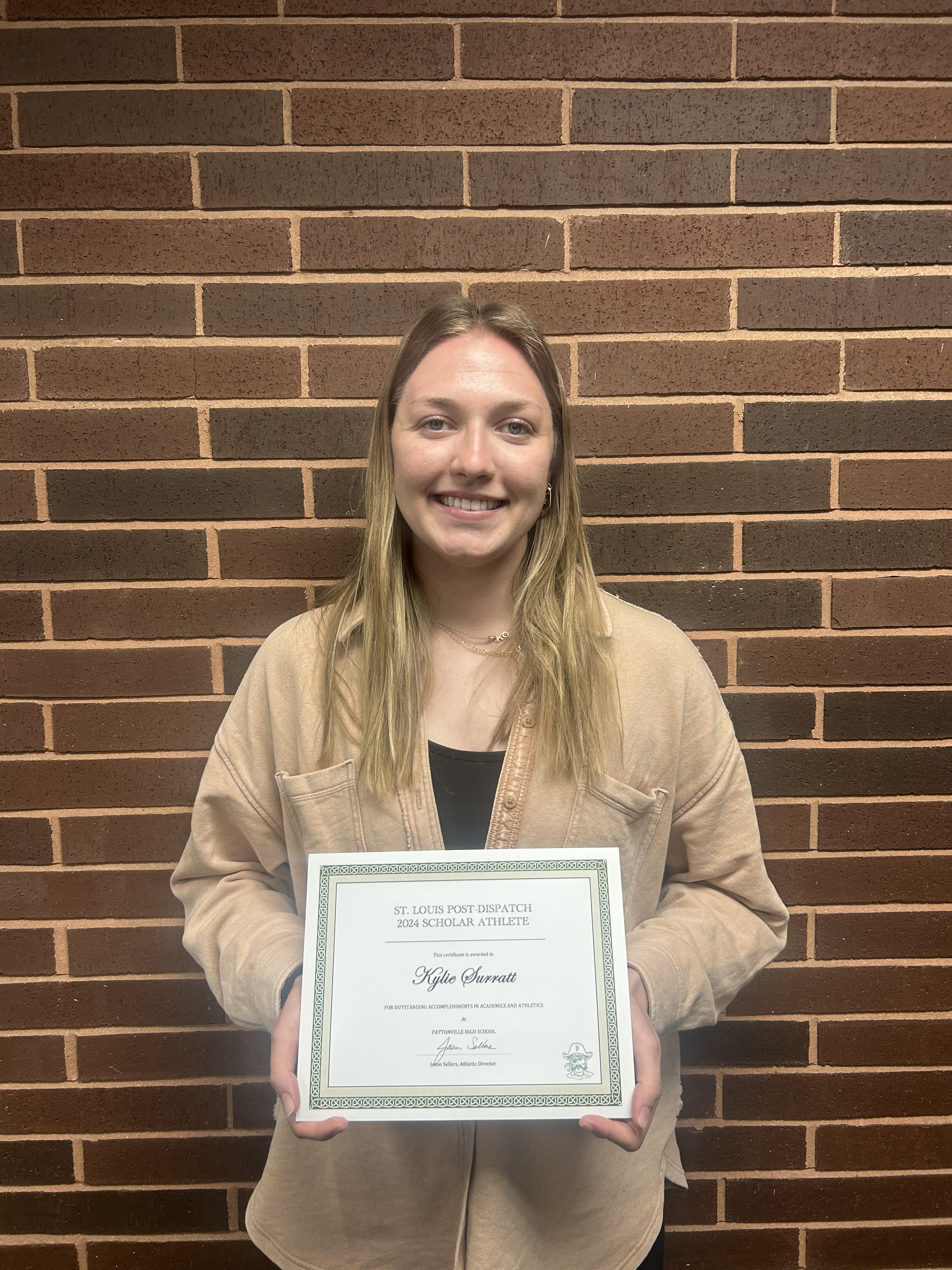 Senior girl stands holding certificate