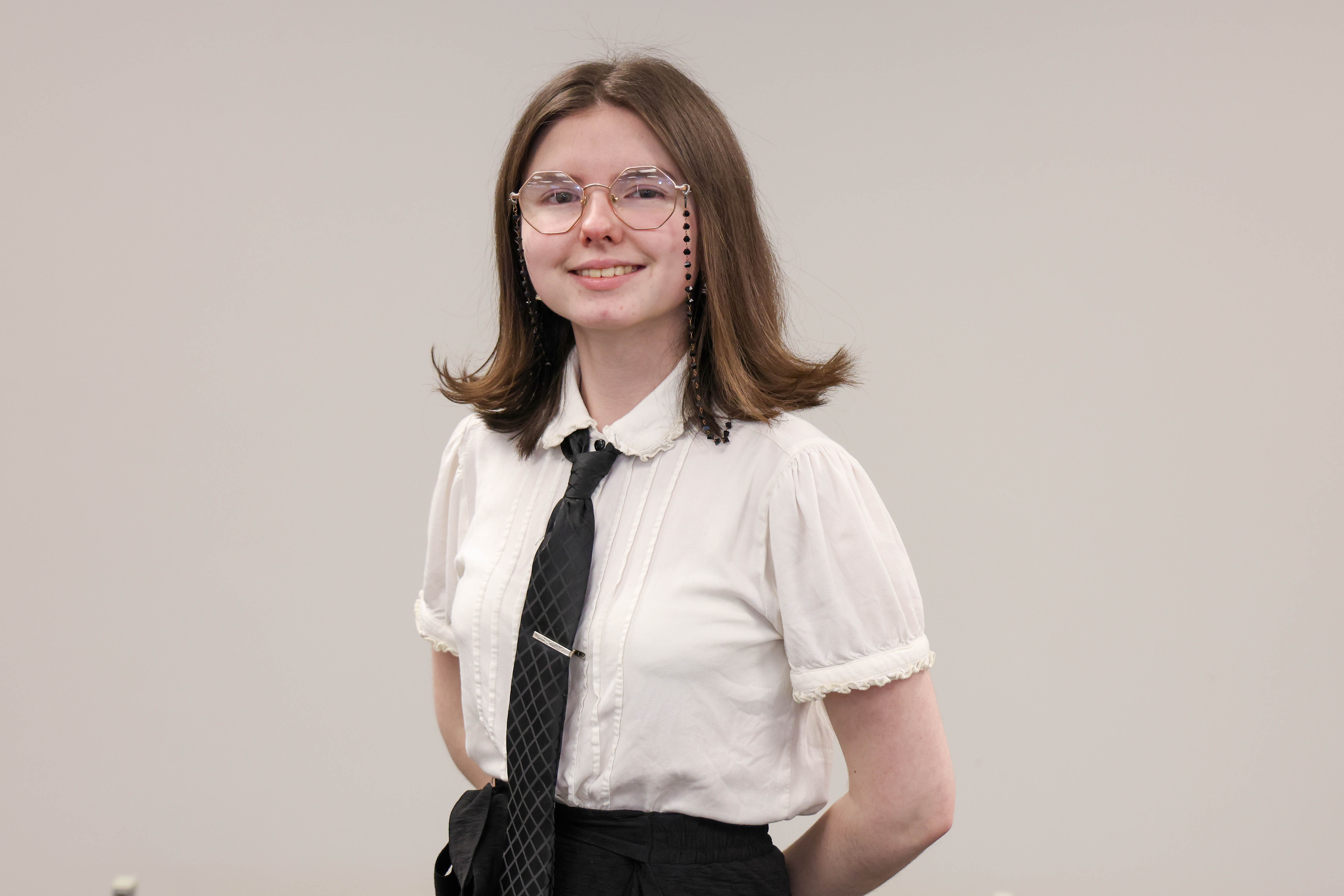 An art student is shown posing during a recognition program.